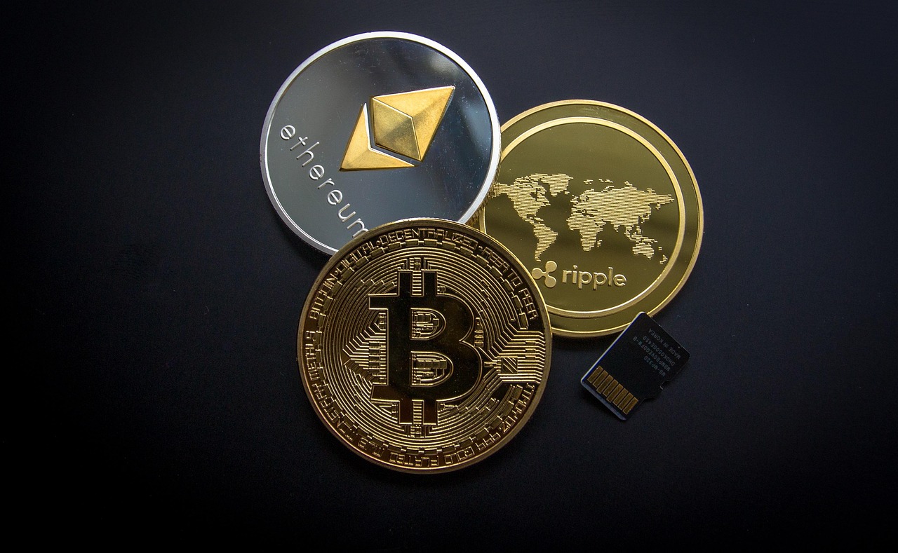 Monety Bitcoin, Ethereum i Ripple symbolizujące analizowane kryptowaluty
