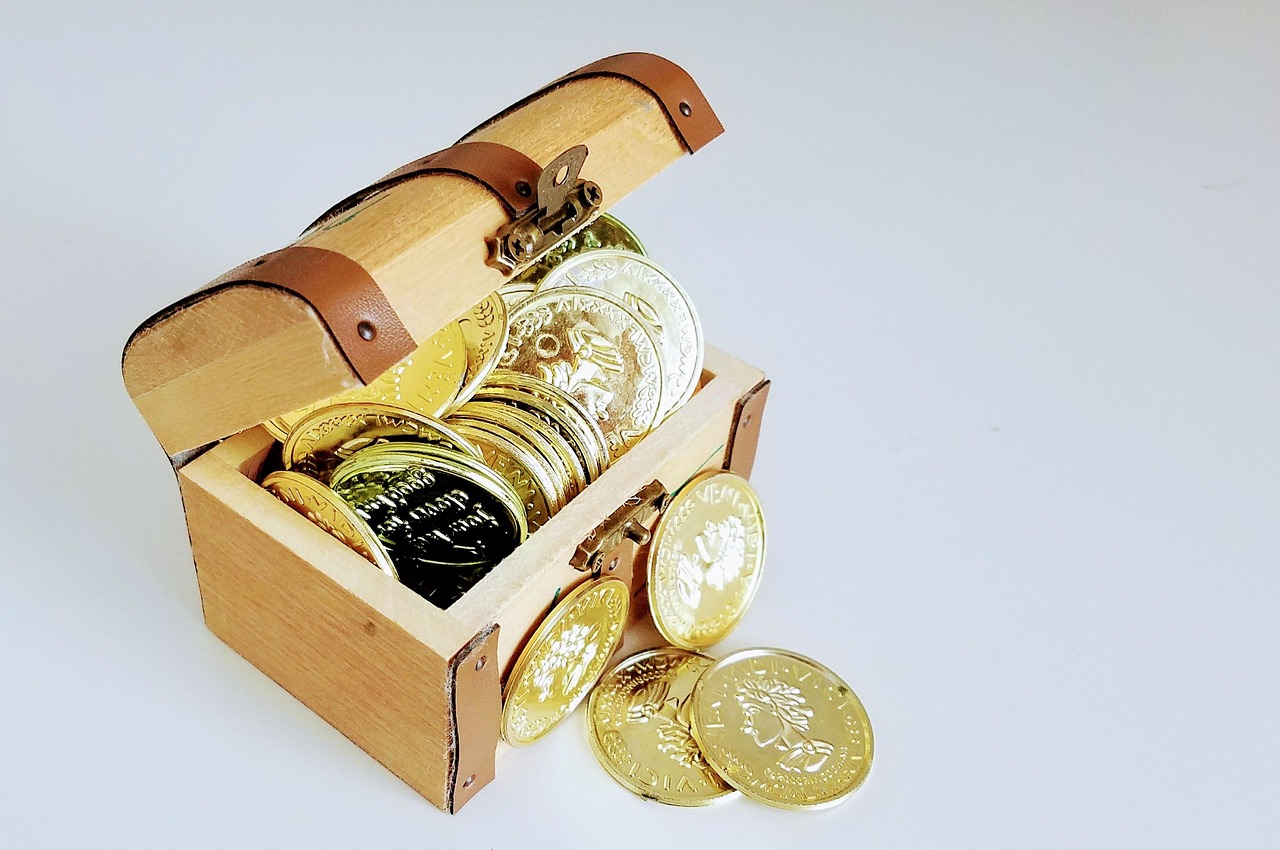 Skrzynka pełna złotych monet jako symbol pomnażania kapitału